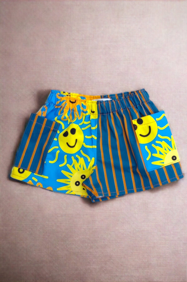 Alana kid's shorts are displayed over grey fabric.
