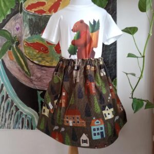 Girls skirt with house print all over is displayed on a mannequin. It is styled with white T-shirt with bear print.