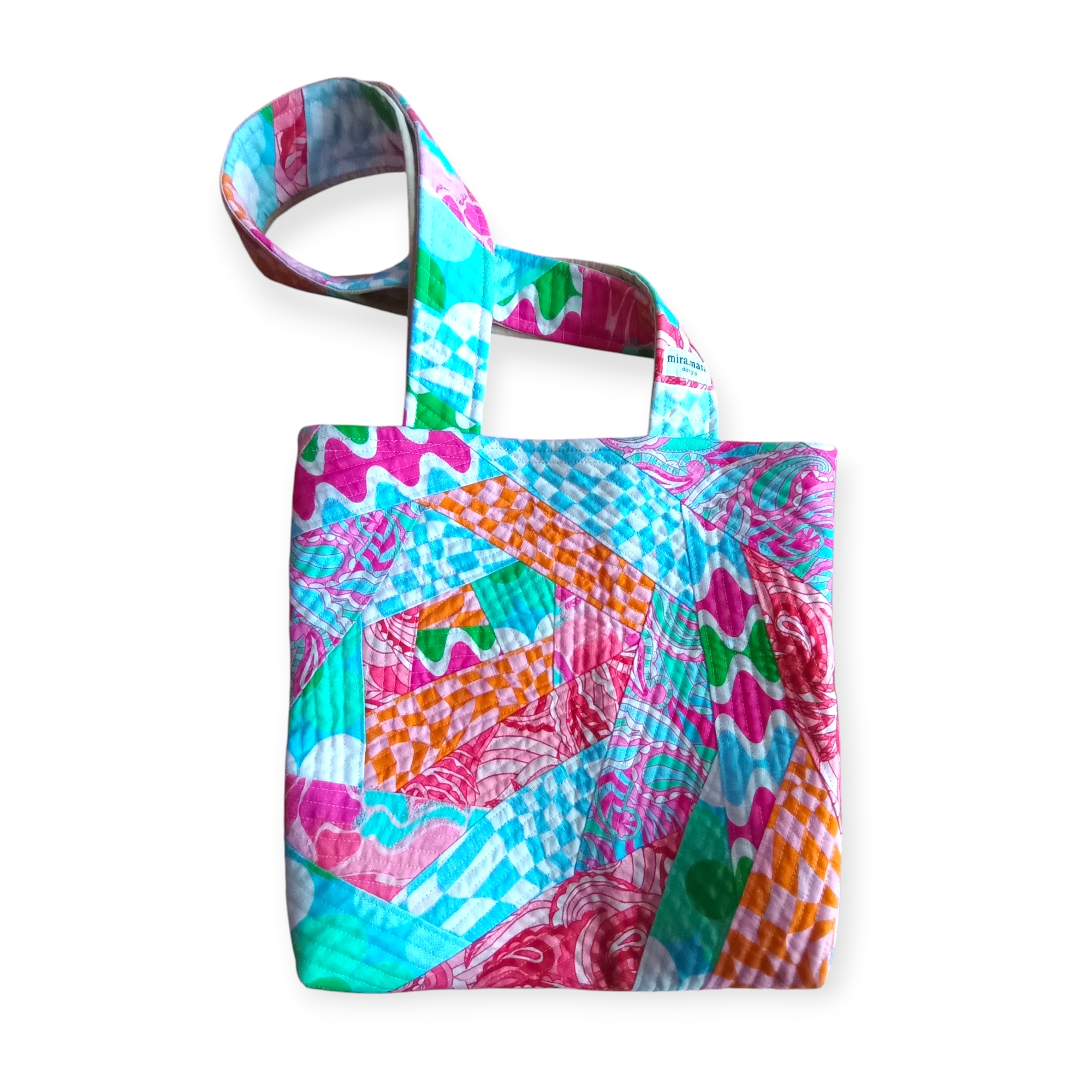 Quilted patchwork retro tote bag in colorful retro inspired print. Its colors are blue, green, pink, white and blue